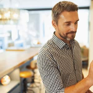 man adjusting digital thermostat at home